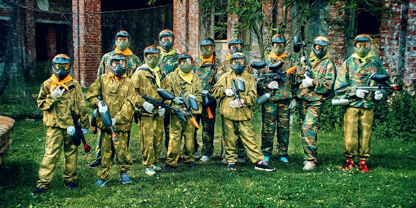 View of a group of friends wearing the clothes for a paintball match and holding their shooting guns