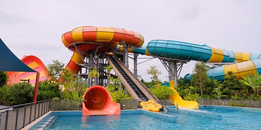 An image of a colourful water slide in a water park near Vasai Virar curving with trees