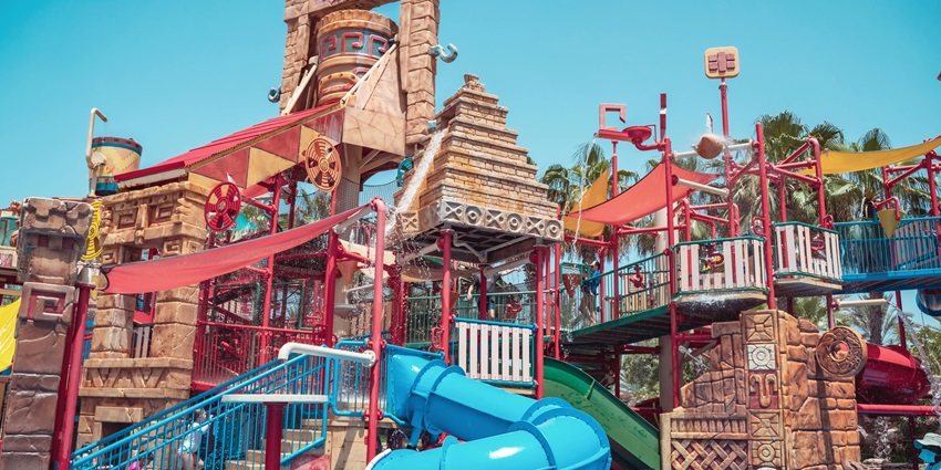 An image of Colorful slides at one of the water parks in Virar leading into a refreshing pool.