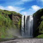 The stunning Panchgani waterfall flows gracefully in a green landscape during the daytime.