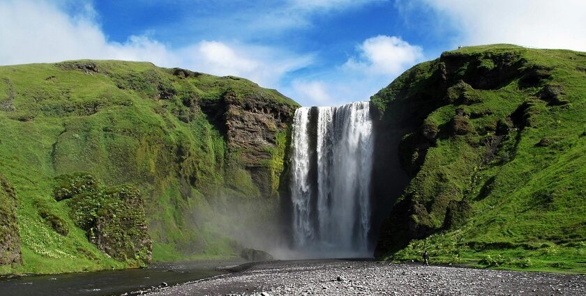 The stunning Panchgani waterfall flows gracefully in a green landscape during the daytime.