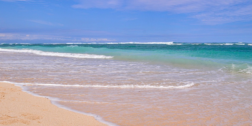 Milky white waves over the coral rocks, adding to the beauty of Pandawa Beach in Bali.