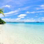 An image of the serene Pandawa Beach with golden sands and clear waters under a blue sky.