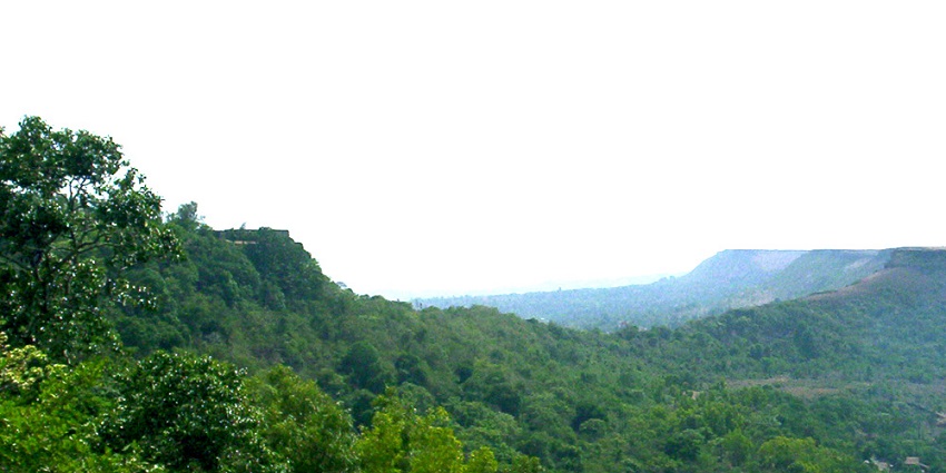 View of Panhala Fort, a historic site surrounded by greenery in Maharashtra, India.