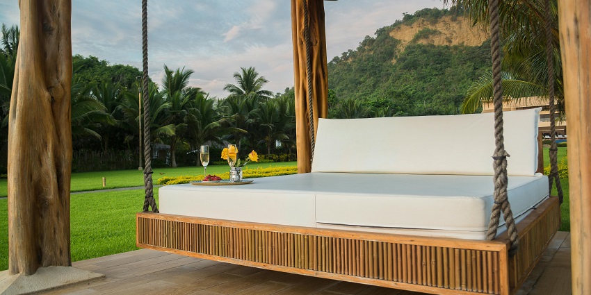 Panoramic Resort, Cozy wooden framed hanging bed surrounded by green grass