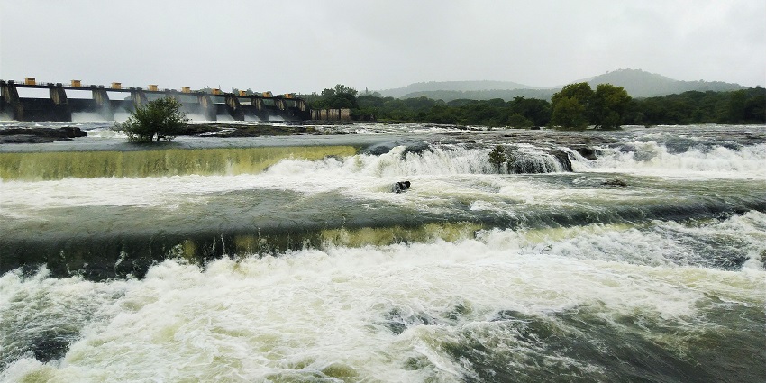 A glimpse of the scenic Panshet Dam nestled amidst verdant hills with serene waters.