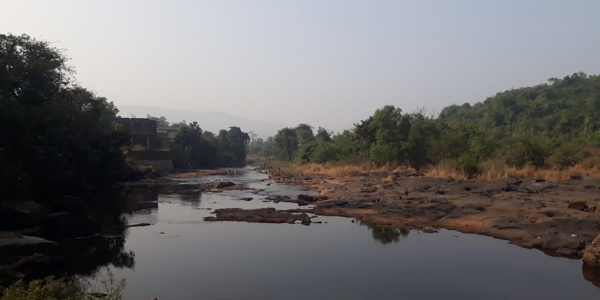 An image view of Panshet Dam surrounded by lush greener, mountains, and water.