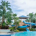 A vibrant view of Paradise funland Water Park showcasing exciting water slides, a wave pool, and greenery