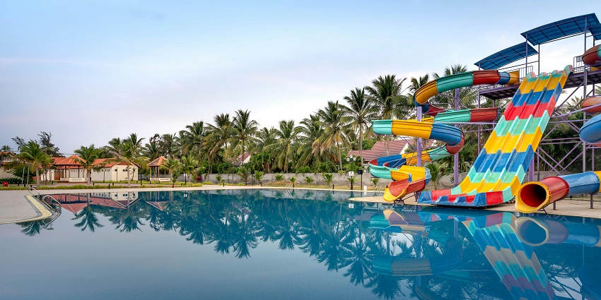 A scenic view with a large pool in the background surrounded by palm trees.
