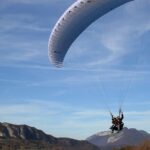 A child enjoys a thrilling ride while paragliding in Ladakh's stunning landscapes.