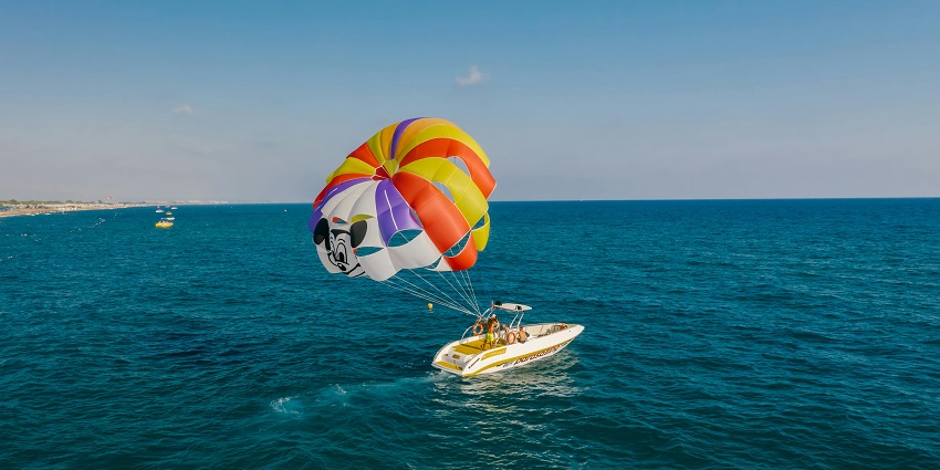 An image of a parasailer gliding above the beautiful landscape of Kamshet, with lakes below.