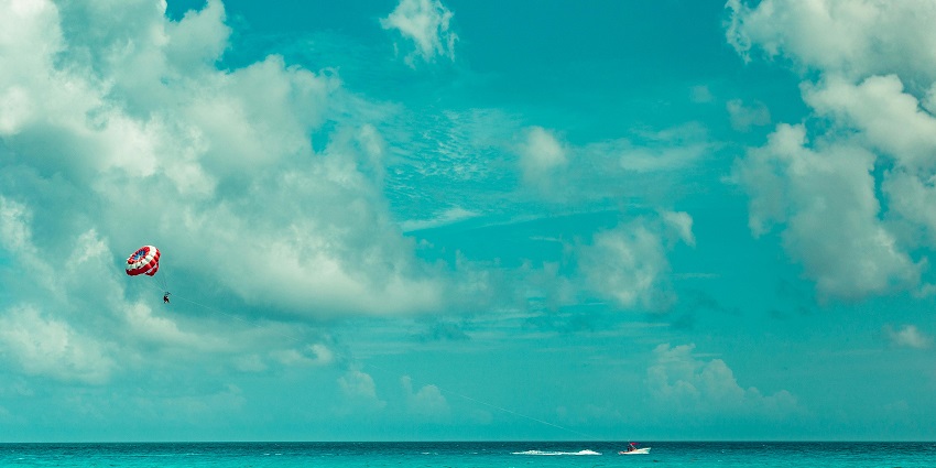 An image of a person parasailing above the sea, one of the best water sports in Mumbai.