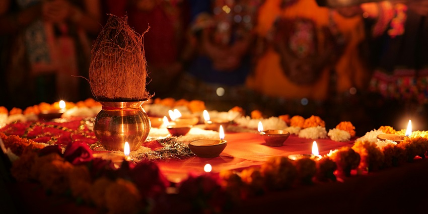 A picture of a plate decorated with flowers and diyas which is used to pray in front of God