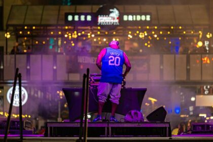 An image of a DJ performing at a vibrant night street event in North Goa, India