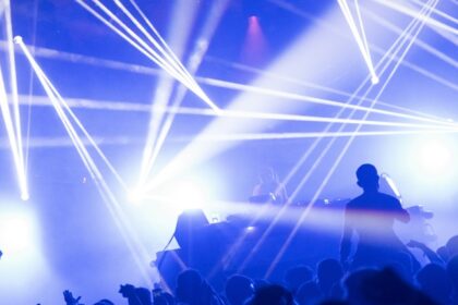 An inside view of a club decked with dazzling neon lights and people dancing.