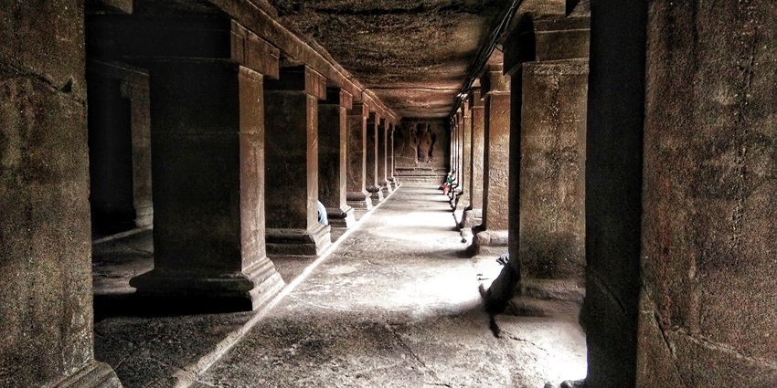 An image of the ancient Pataleshwar Cave Temple carved into rock with historical carvings.