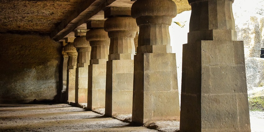 A picture of a cave with pillars in a temple premises