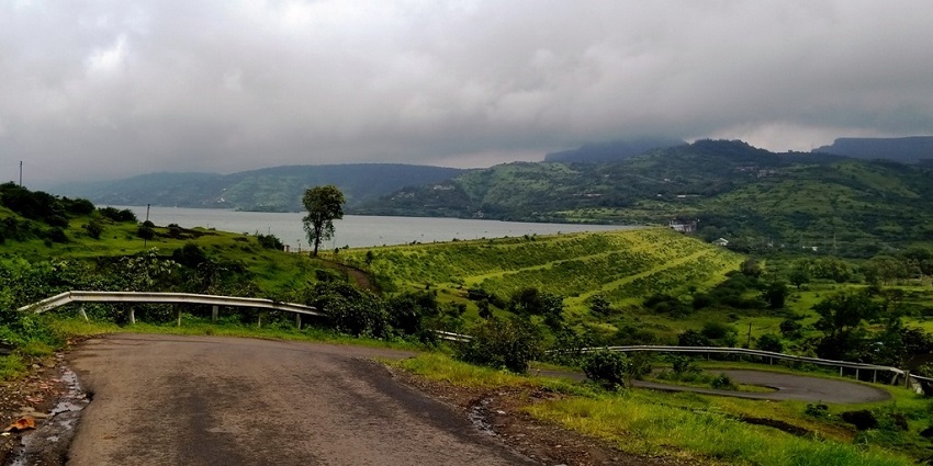 The Pawna Dam during the rainy season with dark clouds overhead.