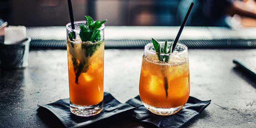 Image of 2 soft drinks in orange colour served in small black trays