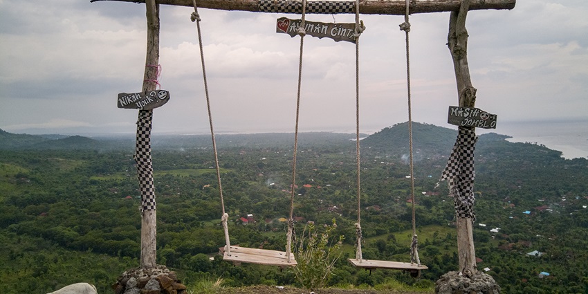 Picturesque view of Pemuteran swing overlooking lush green hills in Pemuteran village