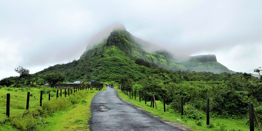 An image of a photographer capturing panoramic views of Visapur Fort trekking.