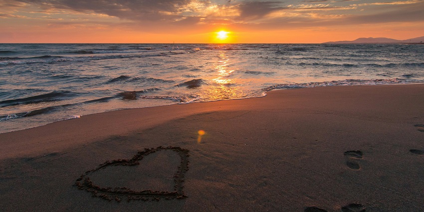 An image of a sunset over Balangan Beach, casting a golden glow on the shoreline.