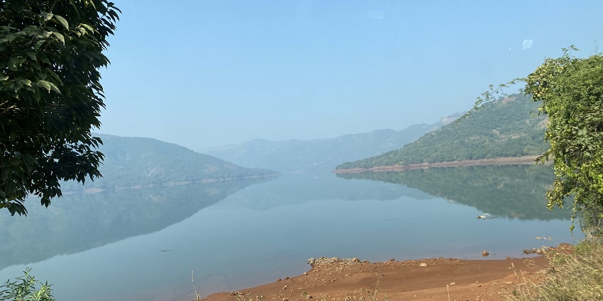 Temghar Dam with the flow of water and some adjacent green mountains on the backside.