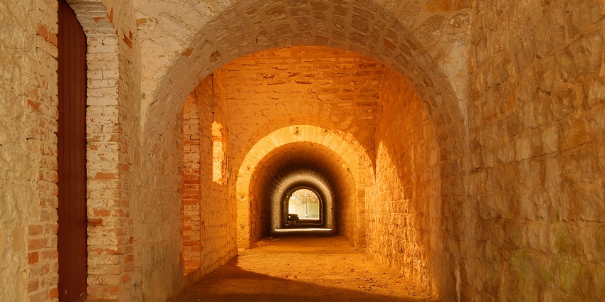 Inside a fort of sturdy stone walls and empty halls with sunlight coming from the window