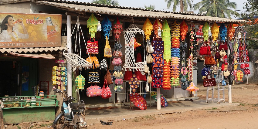 Handicrafts shop with a display of lanterns, wall hangings, bags, and umbrellas in Pipili.