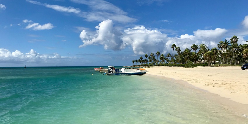 A glimpse of shimmering waters meeting the golden shorelines decked with colourful boats.