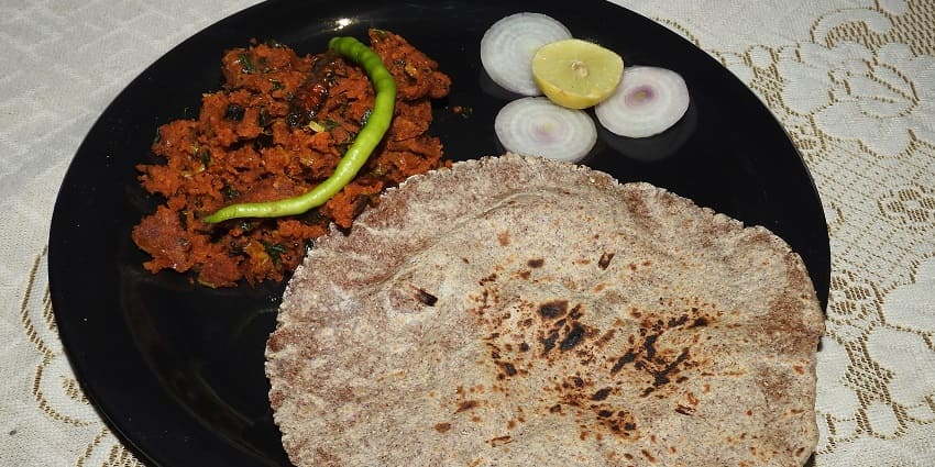 Pithla Bhakri: A rustic and flavorful staple served in a ceramic plate with traditional gravy
