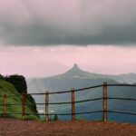 An image of a couple at Irshalgad fort peak as seen from Malang Point at Matheran.