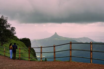 An image of a couple at Irshalgad fort peak as seen from Malang Point at Matheran.