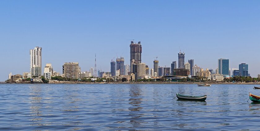 A picture of Mumbai’s skyline, featuring buildings, boats, sea, and lush greenery.