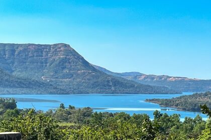 A breathtaking vista of shimmering blue waters surrounded by majestic green peaks.