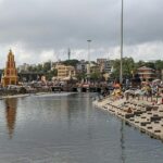 A glimpse of a ghat in Maharashtra bustling with people and featuring azure waters.