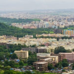 A vibrant aerial view of places to visit in Virar showcasing lush greenery amidst urban buildings.