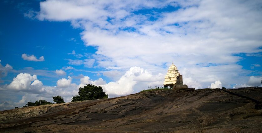 A glimpse of a temple nestled on a hill and surrounded by misty clouds in Karnataka.