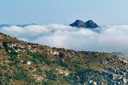 An astonishing view of the towering lush green mountains and blue skies of Karnataka.