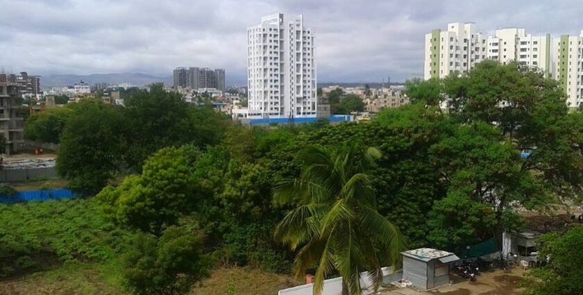 A scenic view of Hadapsar, featuring urban development, lush greenery, and a clear blue sky.