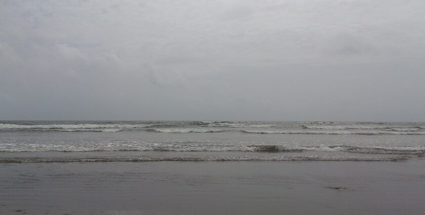 A seaside view of Malvan, showcasing the gentle waves touching the shore.