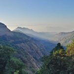 An image of Matheran during summer, showcasing lush greenery and hills in the day.