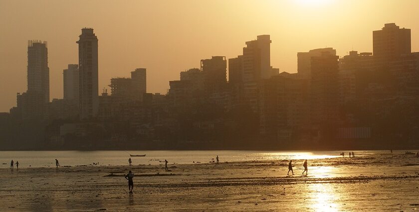 A panoramic view of the skyline of Mumbai just at sunset, with the coastline in the view.