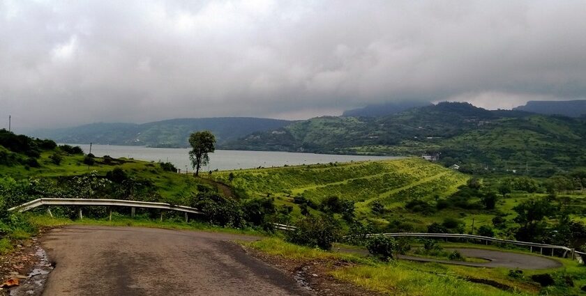 An image of Pawna Lake surrounded by lush greenery and mountains.