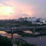 A panoramic view of Pune's scenic landscape, featuring lush greenery, sea, and buildings.