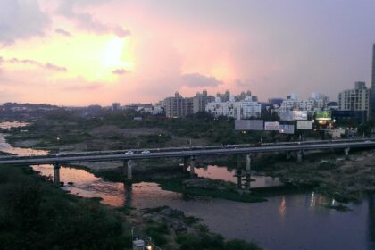 A panoramic view of Pune's scenic landscape, featuring lush greenery, sea, and buildings.