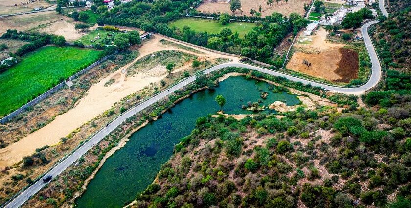 A breathtaking aerial view of a lush green valley with a stream of water flowing through.