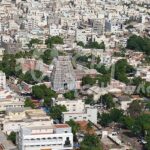 A picture capturing the aerial view of Karur featuring many white houses and trees.