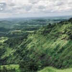 Breathtaking view of a lush green valley in Nashik under clear blue skies during the day.