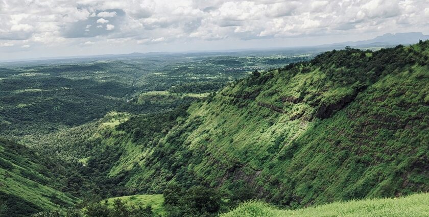 Breathtaking view of a lush green valley in Nashik under clear blue skies during the day.